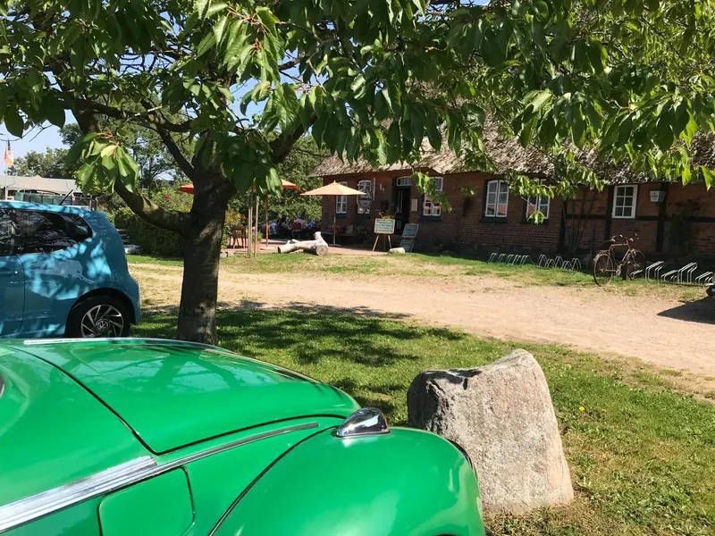 Café Brandtschatz mit Terrasse und einem grünen Oldtimer im Vordergrund