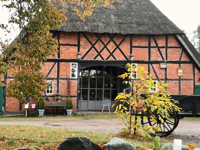 Fachwerkhaus mit Reetdach und herbstlichem Laub in Anker