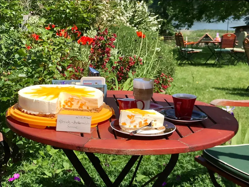 Pfirsich-Buttermilch-Torte mit Kaffee im Garten des Café Brandtschatz